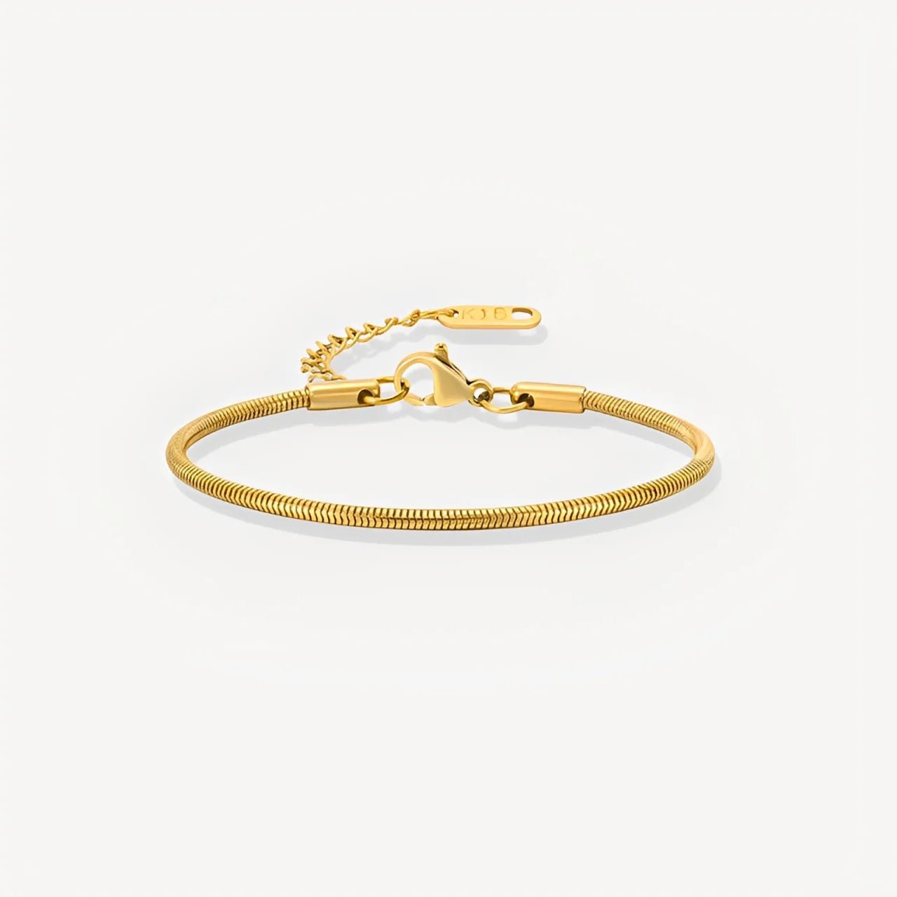 Gold bracelet on a light gray background