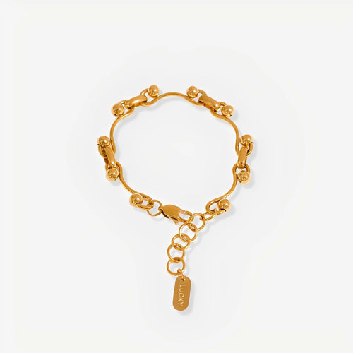 Gold chain bracelet with a tag on a white background
