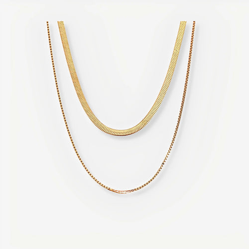 Two gold necklaces on a white background