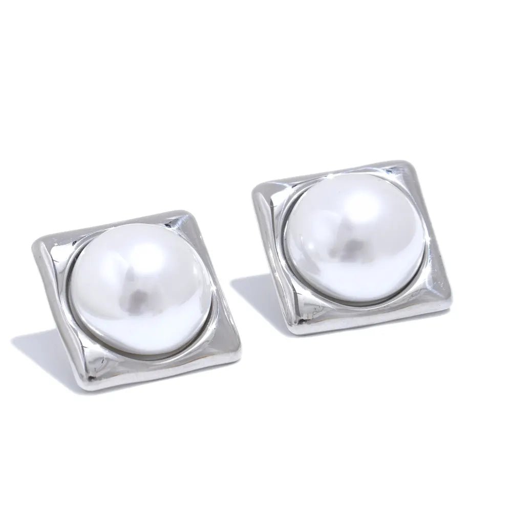 Pair of square-framed earrings with round pearls on a white background