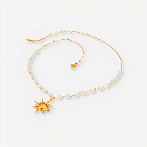 Gold necklace with sun pendant on a white background