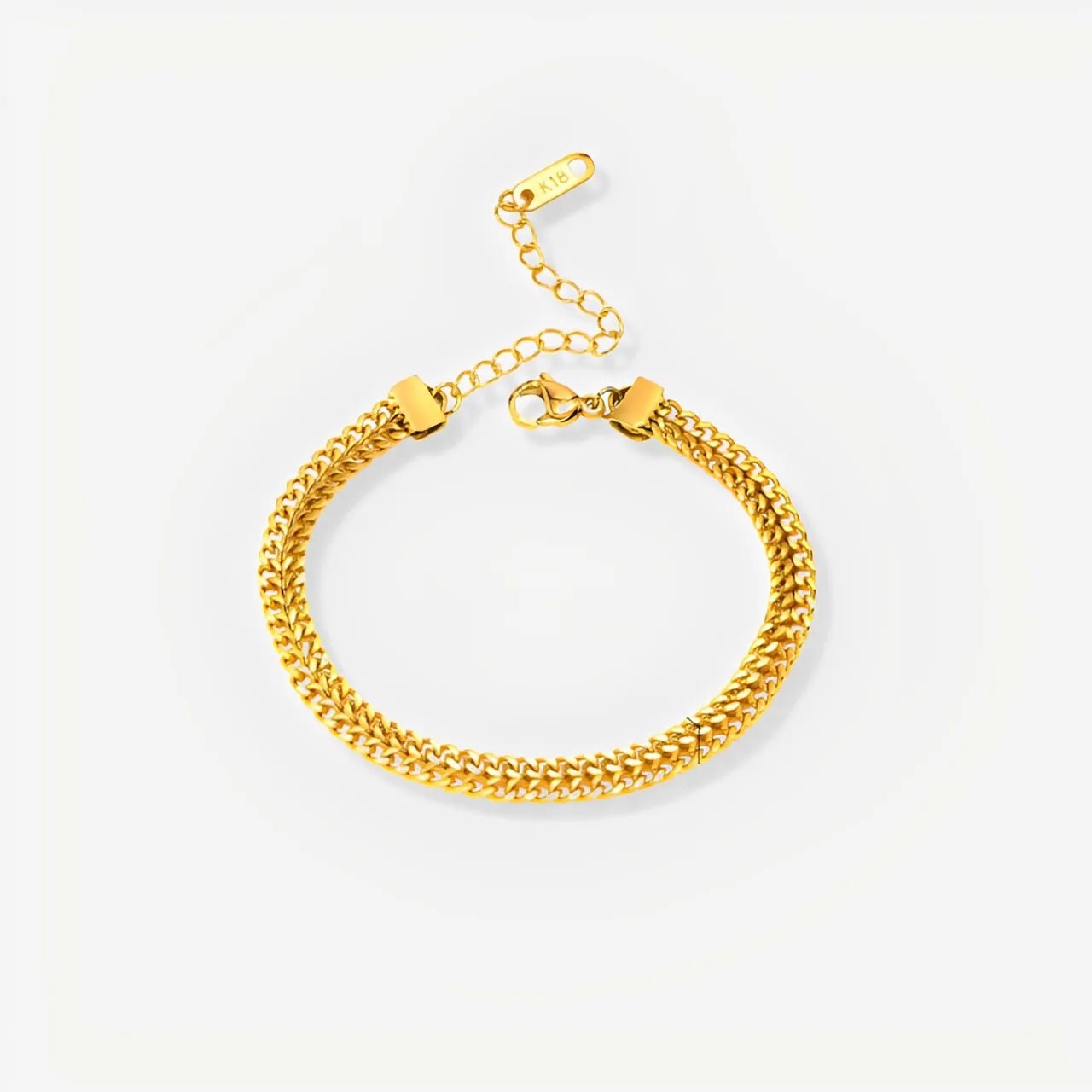 Gold chain bracelet on a light gray background