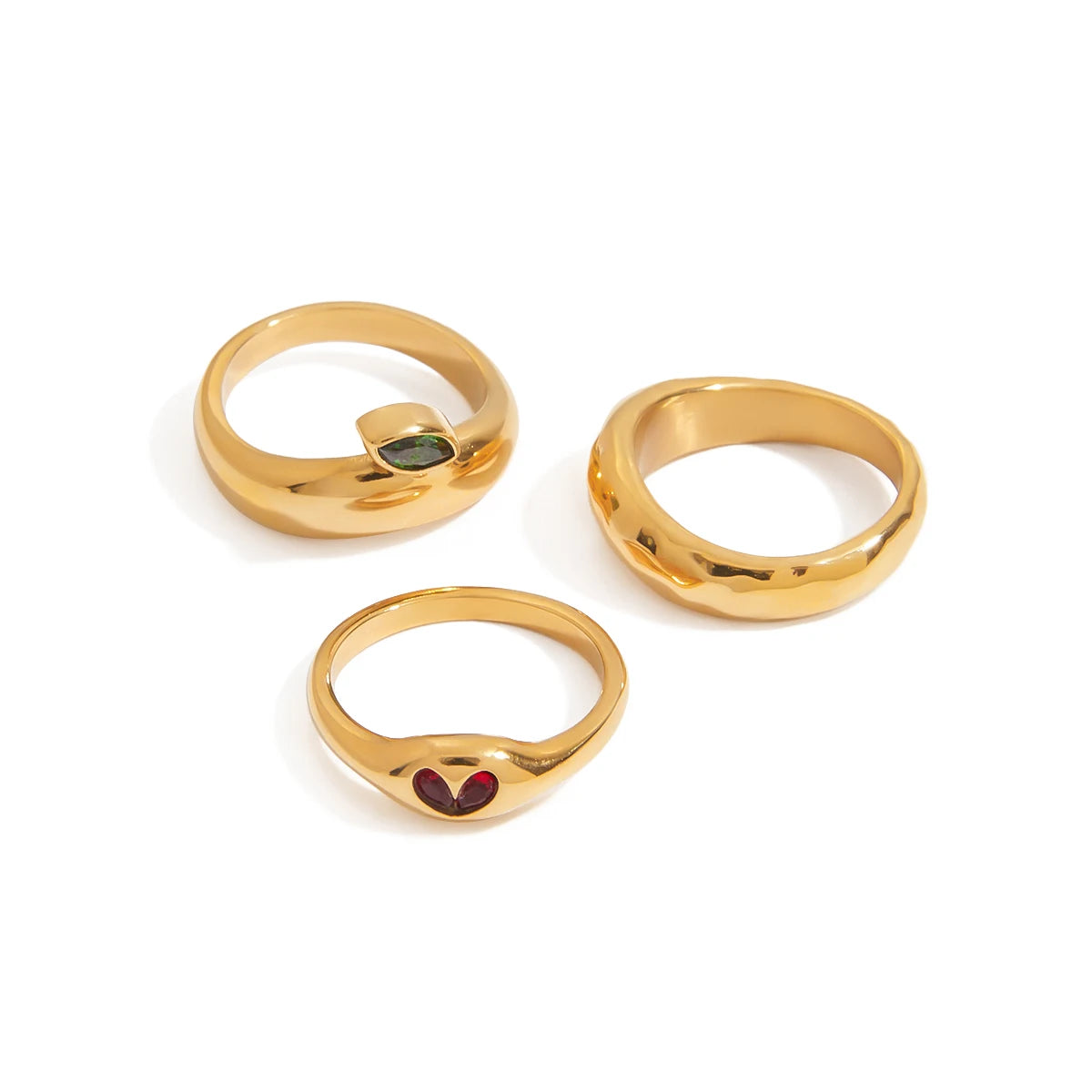 Three gold rings with gemstones on a white background
