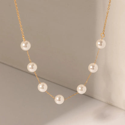 Pearl necklace with gold chain on a neutral background