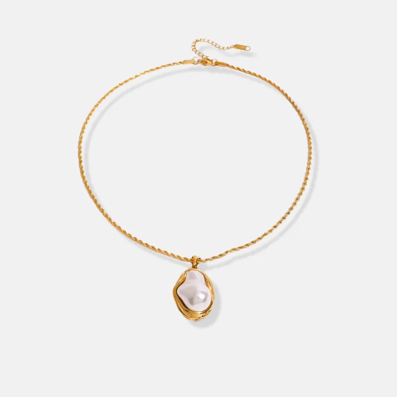 Gold necklace with a pearl pendant on a light gray background