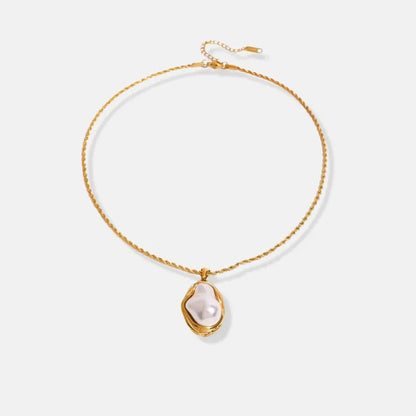 Gold necklace with a pearl pendant on a light gray background