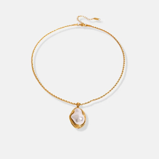Gold necklace with a pearl pendant on a light gray background