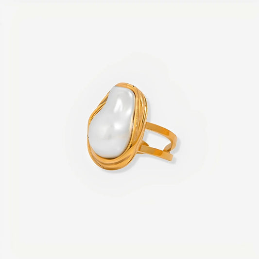 Gold ring with a large white pearl on a light gray background