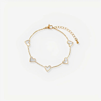 Gold bracelet with heart-shaped charms on a light beige background