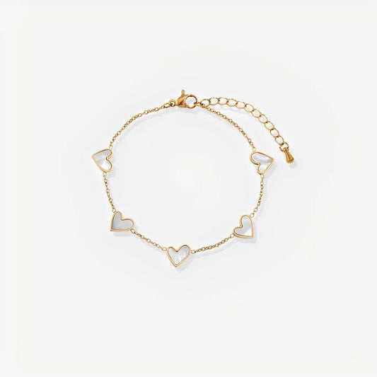 Gold bracelet with heart-shaped charms on a light beige background