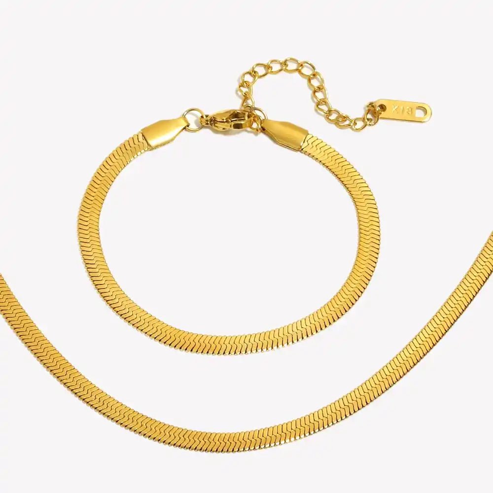 Gold bracelet and necklace set on a white background
