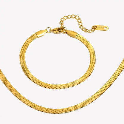 Gold bracelet and necklace set on a white background