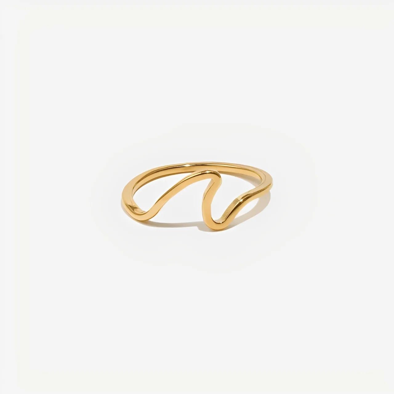 Gold ring with a wavy design on a white background