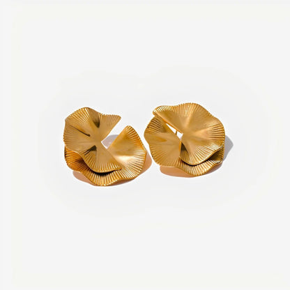 Pair of gold earrings on a light beige background