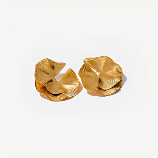 Pair of gold earrings on a light beige background