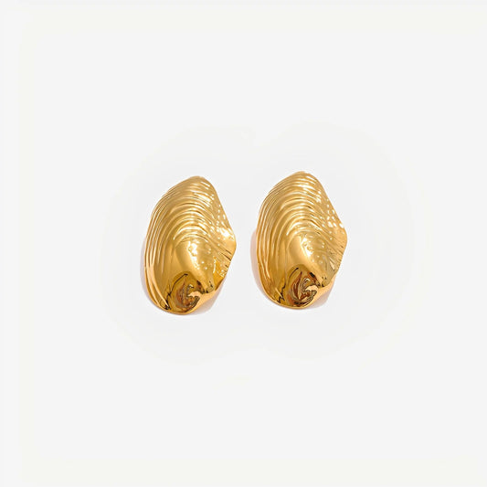 Gold shell-shaped earrings on a light gray background