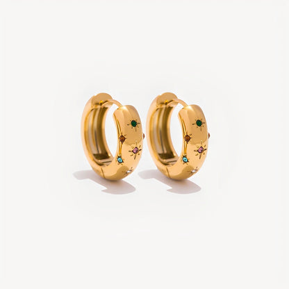 Gold hoop earrings with embedded gemstones on a white background