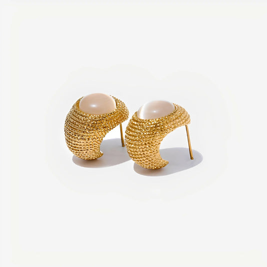 Pair of gold earrings with pearl-like centers on a white background
