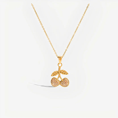 Gold necklace with a cherry pendant on a white background
