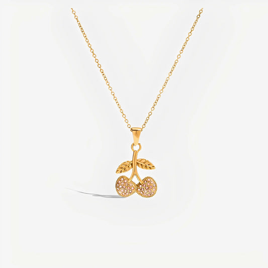Gold necklace with a cherry pendant on a white background