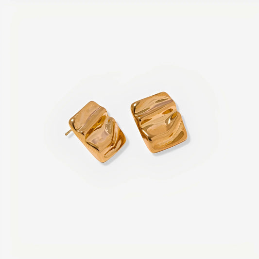 Gold square earrings on a light gray background
