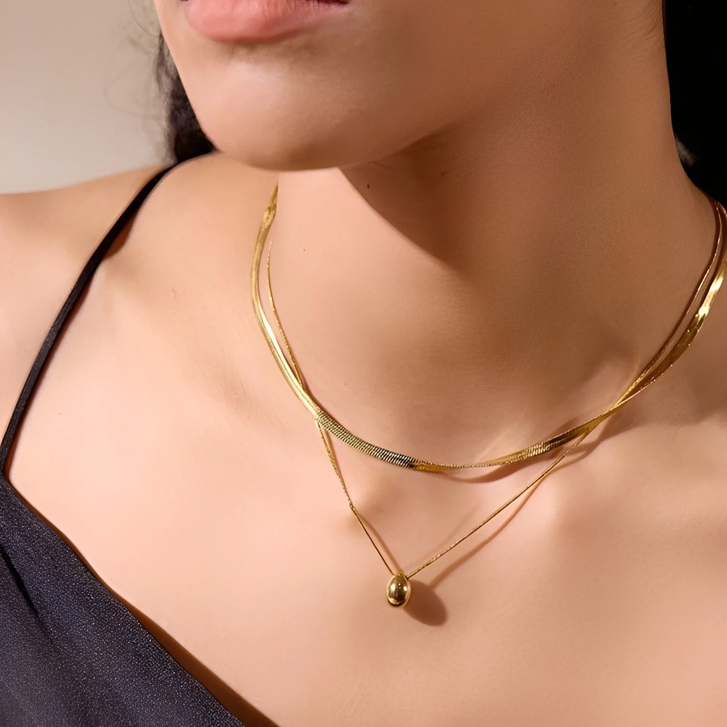 Gold necklace on a model with a neutral background