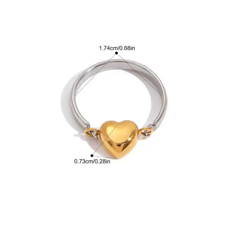 Two-tone ring with a gold heart-shaped center on a white background