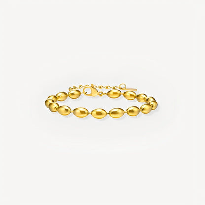 Gold bracelet on a light gray background