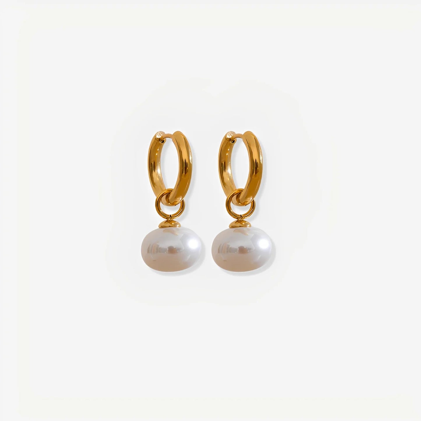 Gold hoop earrings with pearl drops on a white background