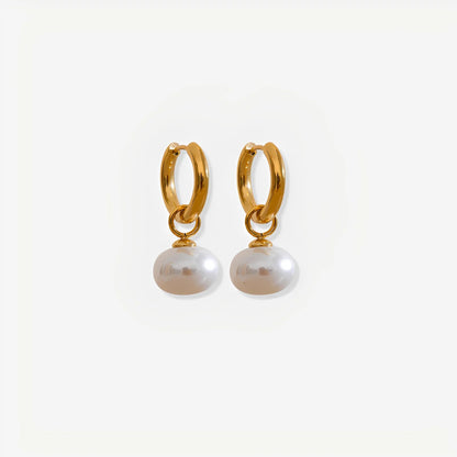 Gold hoop earrings with pearl drops on a white background