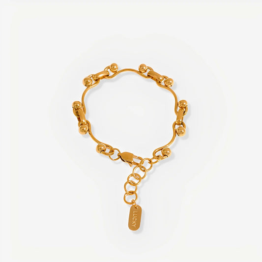 Gold chain bracelet with a tag on a white background