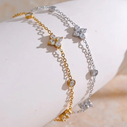 Two gold and silver bracelets with diamond-like stones on a light background