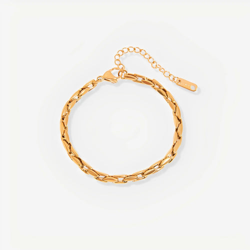 Gold chain bracelet on a light beige background