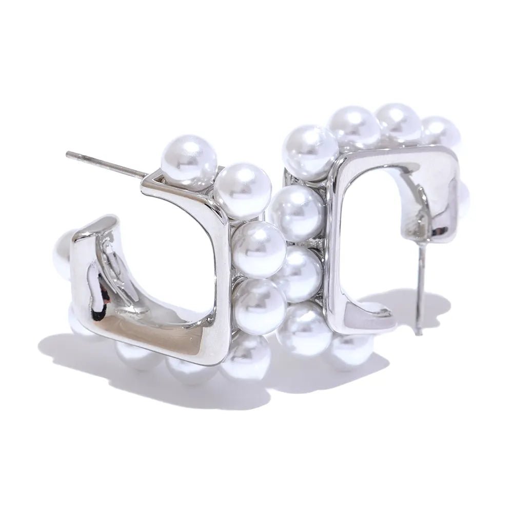 Silver hoop earrings with pearl-like beads on a white background