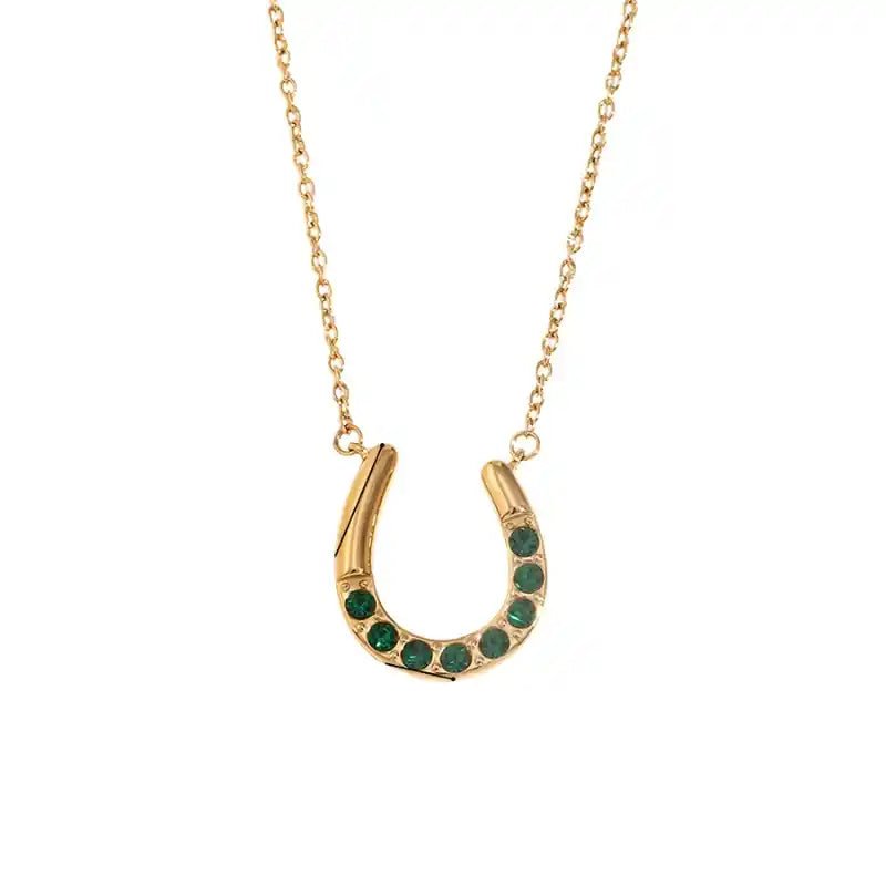 Gold horseshoe necklace with green stones on a white background