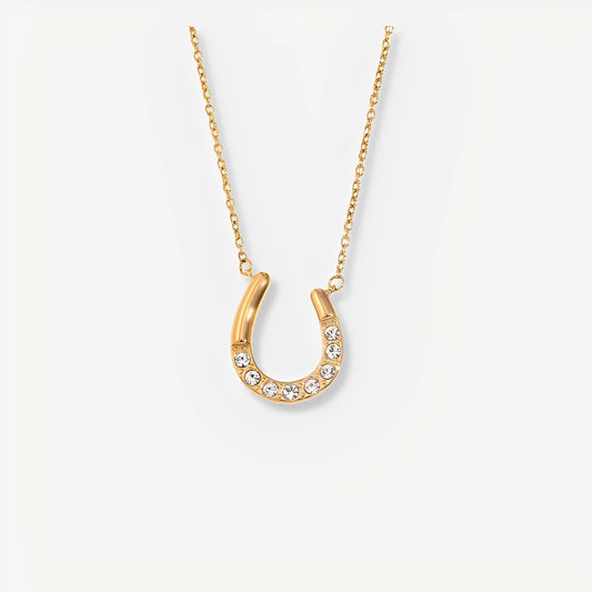 Gold horseshoe necklace with crystals on a white background