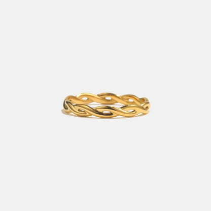 Gold ring with a wavy design on a white background
