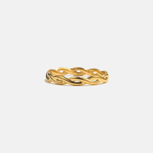 Gold ring with a wavy design on a white background