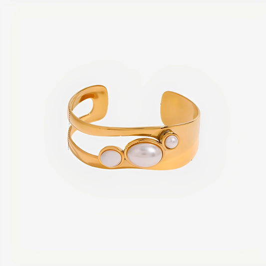 Gold bracelet with embedded pearls on a white background