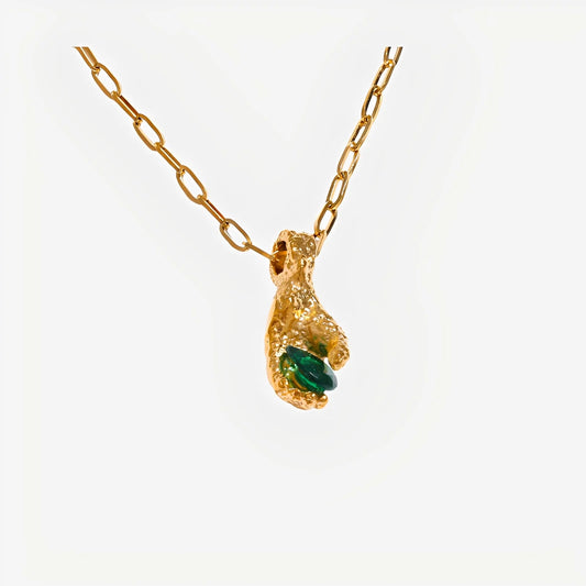 Gold necklace with a unique pendant on a white background