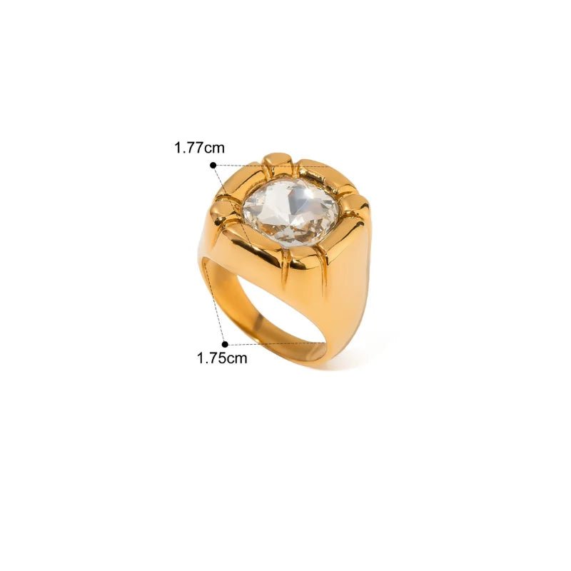 Gold ring with a large central gemstone on a white background