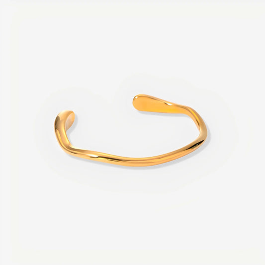 Gold bangle on a light gray background