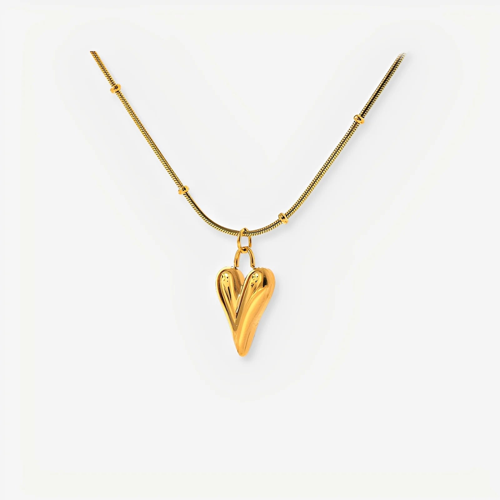 Gold heart-shaped pendant necklace on a white background