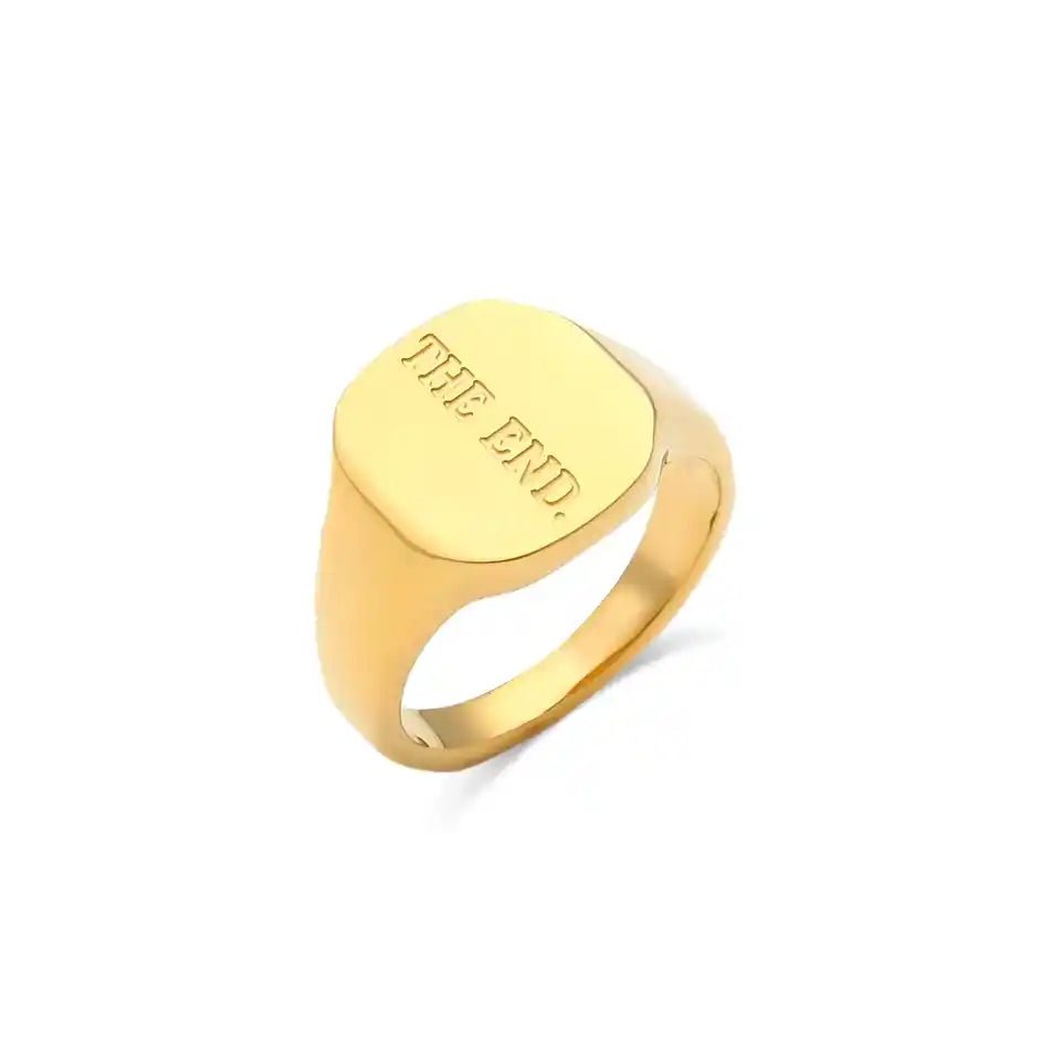 Gold ring with 'THE END' engraving on a white background