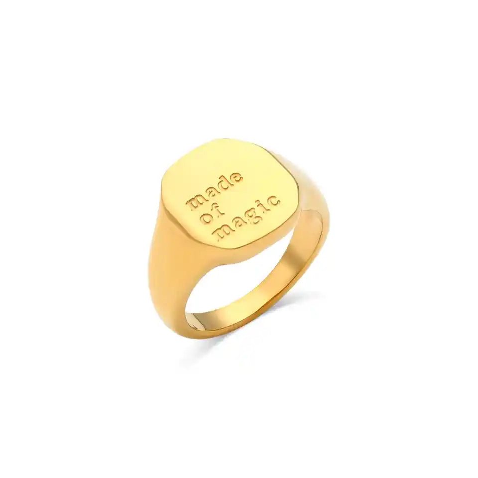 Gold ring with 'made of magic' engraving on a white background
