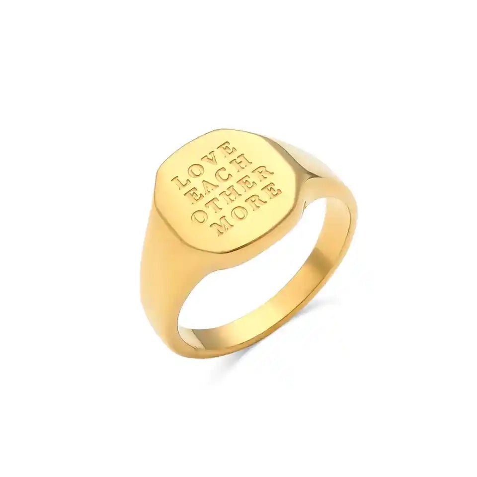 Gold ring with engraved text on a white background