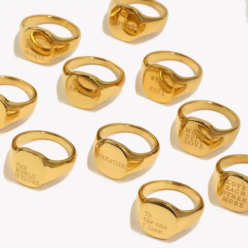 Gold rings with engraved text on a white background