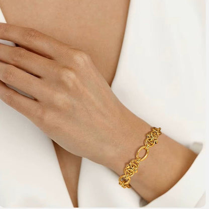 Gold bracelet on a person's wrist with a neutral background
