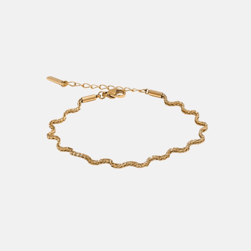 Gold bracelet on a light gray background