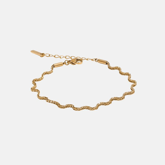 Gold bracelet on a light gray background
